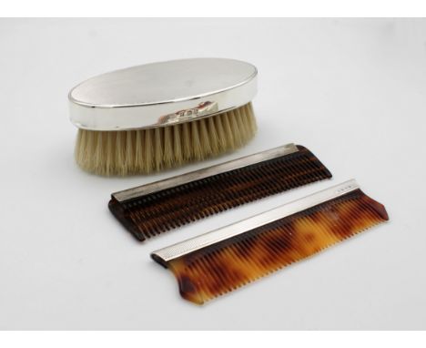 An engine turned silver brush with two combs in fitted caseBirmingham, brush maker ABJ, brush 13.2cm. wide.
