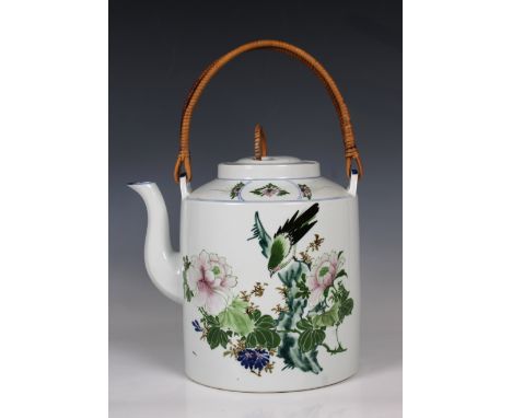 A 20th century Chinese porcelain teapot of large proportions with cane handle, hand painted with a bird among flowers and fol