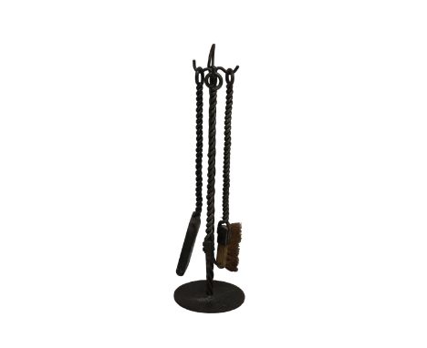 A set of three 20th century rope twist steel fire ironscomprising a shovel, brush and poker with a rope twist steel stand.