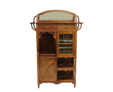 An Art Nouveau mahogany cabinetthe oversailing rectangular top with shaped mirror back, above two short drawers, nine paneled