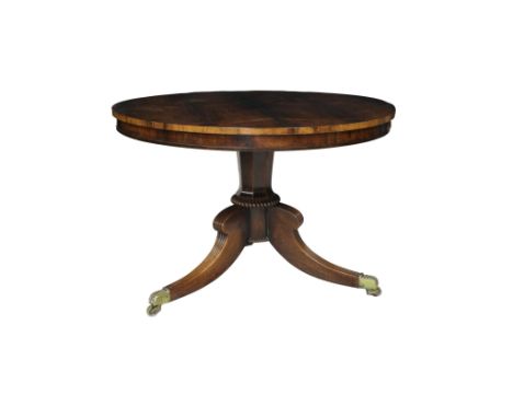 A George IV rosewood breakfast table with a circular topthe central pedestal raised on three reeded hipped sabre legs with ac