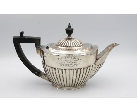A George V silver teapotGoldsmiths &amp; Silversmiths Co Ltd, Sheffield, 1917, of oval half fluted tapering form, the teapot 