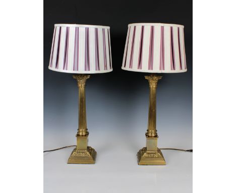 A pair of 20th century brass table lampswith fluted Corinthian column bases, cream and burgundy pleated shades, 48cm. high.