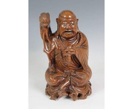 Oriental carved wooden figure of a laughing Buddha (Guernsey bidders ONLY)seated, holding beads and carrying a stick, with in