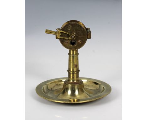 An early 20th century brass cigar cutter in the form of a ship's engine order telegraphon a circular brass ashtray stamped to