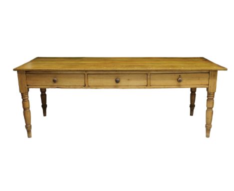 A large Victorian turn top pine kitchen table rectangular oversailing top above three drawers, with turned handles, tapered t