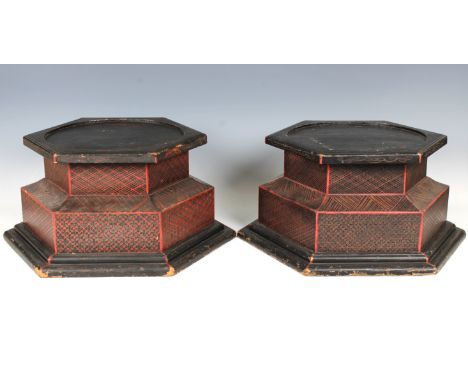 A pair of Chinese hexagonal wooden pedestals/standslikely 20th Century, hand painted with geometric designs in red and black,