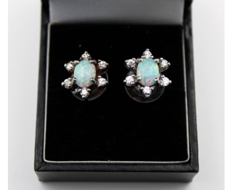 A pair of silver, opal and white stone stud earrings.