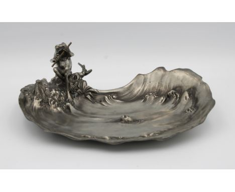 An Italian Art Nouveau pewter dishDesigned by Achille Gamba, depicting a frog playing the flute by a fish pond, stamped to ba