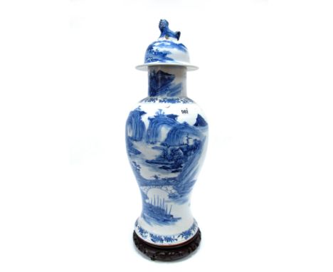 A Chinese Porcelain Blue and White Baluster Vase and Cover, with dog of fo finial, painted with figures in a mountainous rive