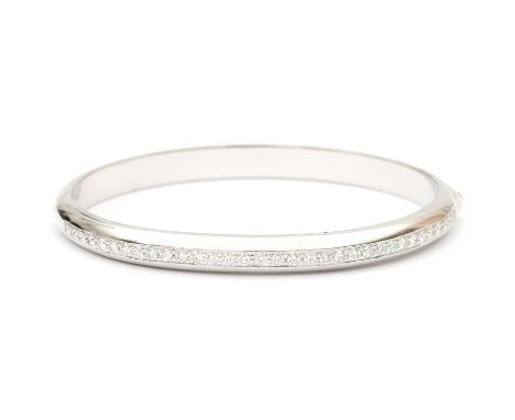 An 18 carat white gold diamond bangle. A rigid bangle set with thirty three brilliant cut diamonds of ca. 0.66 ct. in total, 