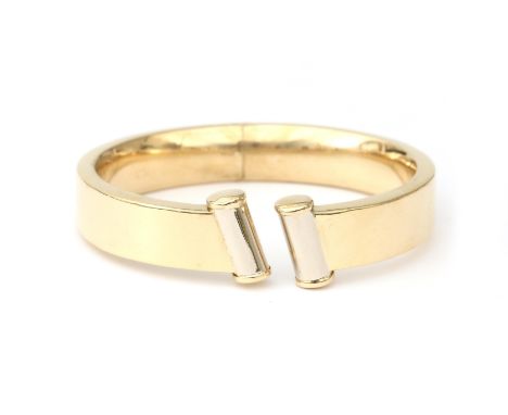 An 18 karat gold bangle. Contemporary design with diagonal opening at the front and a hinge at the back. Provenance: Italy. G