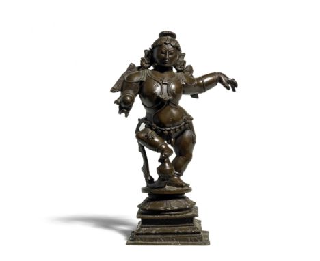 A bronze figure of Krishna South India,  17th/ 18th Centuryon a square stepped base, in a dancing posture on a lotus, holding