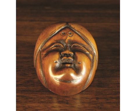 A 19th Century Boxwood Netsuke Mask of Okame, 2 ins (5 cms) in length.
