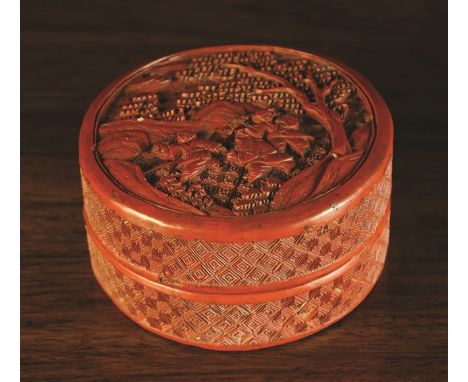 A 19th Century Cinnabar Red Lacquered Cylindrical Box. The lid carved with three boys playing in a landscape, 2 ins (5 cms) h