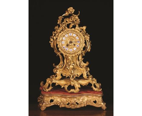 A Fine Quality Louis XV Style Ormolu Mantel Clock by Raingo Frères, Paris. The exuberant scrolling Rococo case surmounted by 