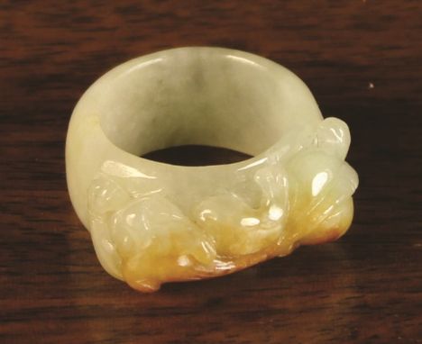 A Chinese Celadon Jade Ring, carved with a Chilong and displaying appealing russet inclusions. 