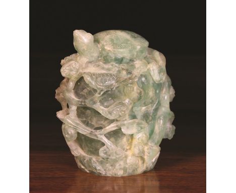 A Jade like Carving of a Tortoise raised on a clump entwined with scrolling stems of leaves, 6½ ins (16.5 cms) in height.