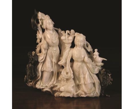 A Fine Chinese Bi-colour Jade Carving of two Female Immortals worked from pale stone; one holding a basket of peaches, the ot