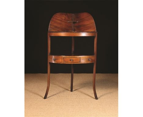 A Georgian Mahogany Corner Wash Stand. The shaped splash back with small triangular shelf above a quadrant top pierced with b