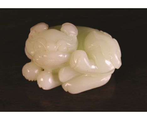 A Celadon Jade Carving of a Kylin, 2 ins (5 cms) high, 3¼ ins (8 cms) long, 2¼ ins (5.5 cms) wide.