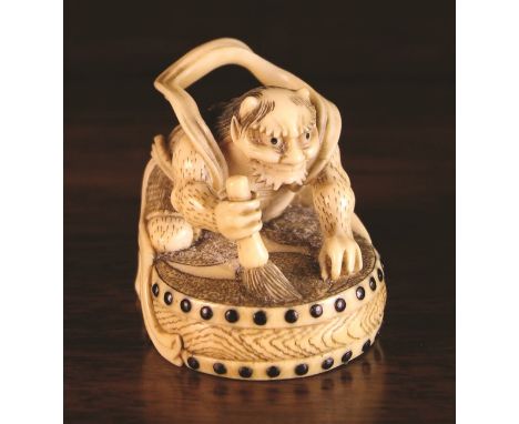 A 19th Century Ivory Netsuke carved in the form of Raijin the Thunder God beating his thunder drum.