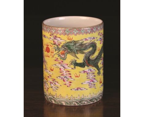 A Chinese Cylindrical Brush Pot decorated in polychrome enamels with a phoenix and dragon chasing a flaming pearl, on a yello