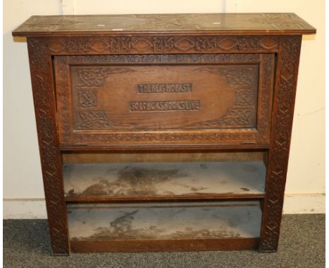 Arts and Crafts carved oak bookcase, decorated allover with Celtic style knot work, the hinged cupboard with verse "There Is 