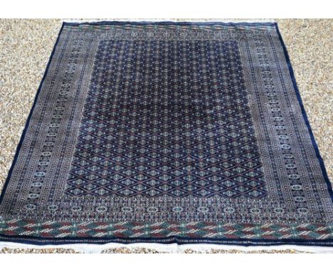 A large Pakistani Turkoman design carpet, the blue ground with repeating gul design and multi-borders, 370 x 285 cm 