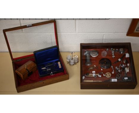 Two table-top dealer's display cases with hinged glass lids, containing various 19th century and later collectables including