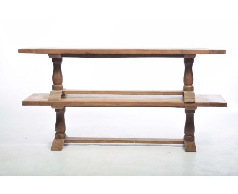A pair of rustic hardwood benchesEach with a slab top supported on two baluster shaped supports with plain cross stretchers a