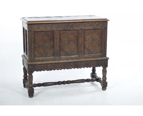 A 17th Century and later carved oak coffer on standThe rectangular hinged top concealing a fitted candle box above a frieze c