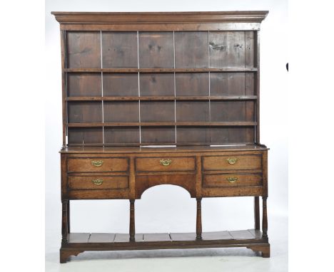 A Georgian oak high back dresser, most likely South WalesThe moulded cornice above three fixed shelves and boarded back, the 