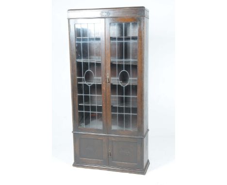 A 1920's oak glazed bookcaseWith a caddy top above two leaded glazed doors enclosing three shelves over two cupboard doors ea