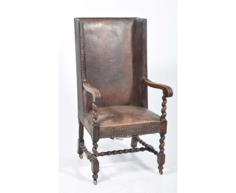 A 19th/20th Century oak and leather high back hall or porters chairThe studded leather wing backs above two channelled downsw