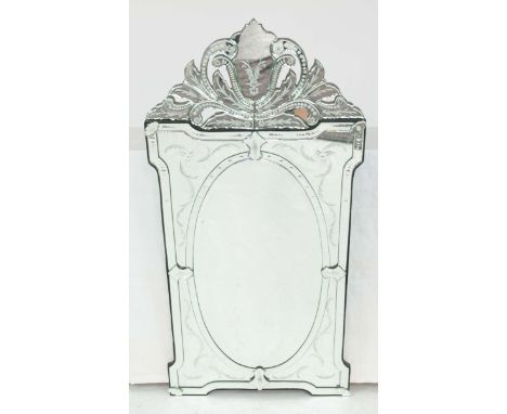 An Italian Venetian style etched glass wall mirrorThe oval central mirror plate with segmented foliate finial, mounted on a s