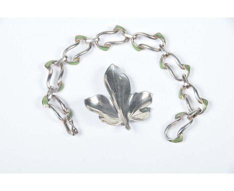 A silver and enamel braceletThe fancy links with green enamel highlighted, together with, a Danish silver leaf brooch (2)