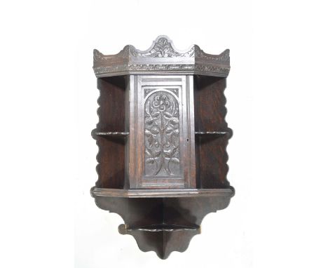 A Victorian oak hanging corner cupboardThe shaped pediment above a single door carved with a foliate design, flanked by two s