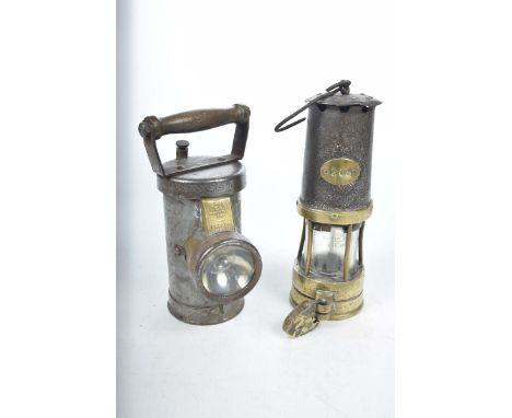 An antique brass and iron minors lamp and a vintage inspection lampThe minors lamp with an oval plaque stamped 205 and the br