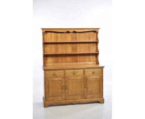An Ercol pine kitchen dresserThe high back with two enclosed shelves above a rectangular moulded top, three frieze drawers, t