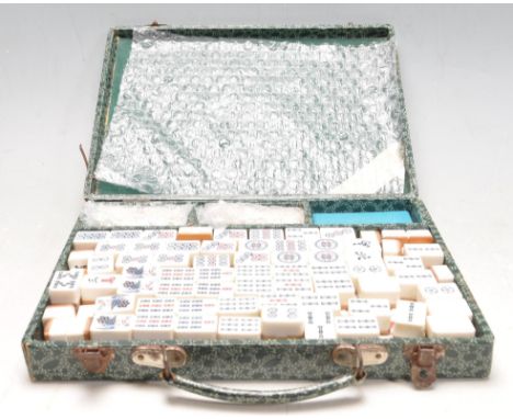 A 20th century vintage Chinese Mahjong game set complete with white counters with character marks and symbols atop and bamboo