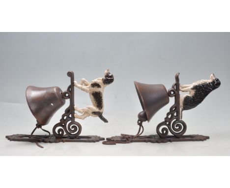 Two vintage style cast metal polychrome bells having a dog in profile to the top over scrolled decoration to the fixing brack