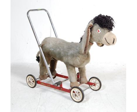 A vintage retro 20th century push along donkey by Merry Thought. The push along / ride along donkey with tubular frame and pl