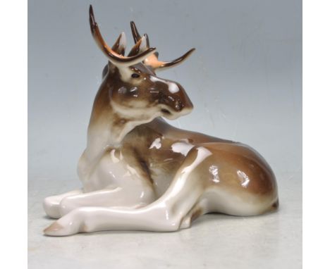 A group of four Russian Lomonsov ceramic animal figurines to include a recumbent moose, two sleeping doe / deer figurines, an