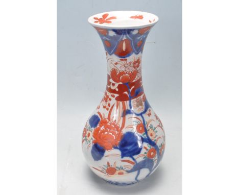 A vintage 20th century Japanese Imari vase having a waisted neck over a bulbous body with red and blue botanical decoration t