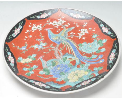 A large early 20th century Japanese oriental ceramic porcelain charger plate. The large circular charger having depicting two