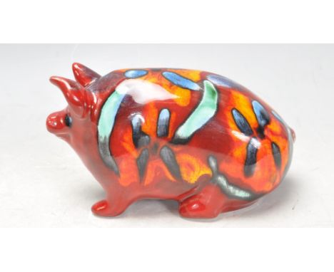 An unusual abstract painted glazed studio art pottery flambé style pig in the manner of Poole pottery. The pig has vibrant br