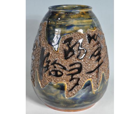 A large contemporary Chinese ceramic vase of bulbous form having a Chinese characters to the central panel with textured back