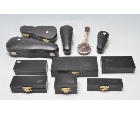 A quantity of miniature musical instruments of various types and proportions to include violins, clarinet, guitar,&nbsp; trom