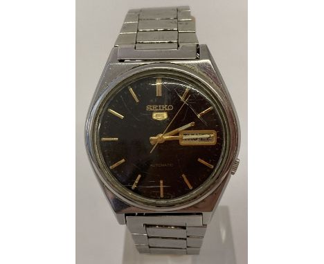 A vintage Seiko men's wristwatch with stainless steel bracelet strap. Working order.Black face with gold tone hour markers an